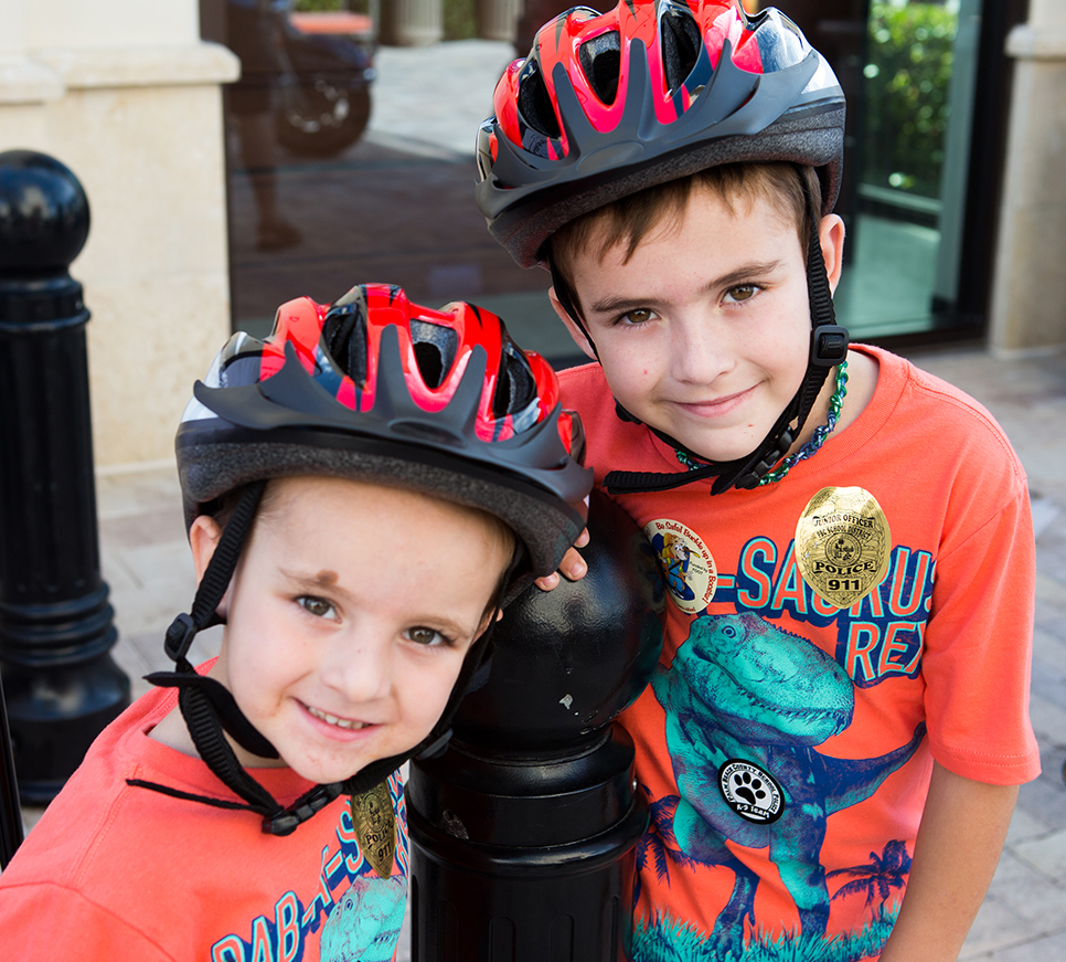 Two young boys with helmets on.