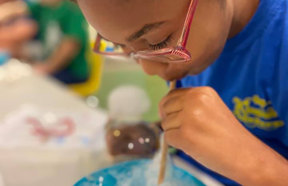 Girl blowing bubbles through straw