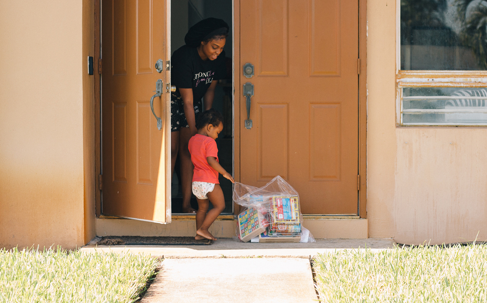 Mother and child picking up bag of toys