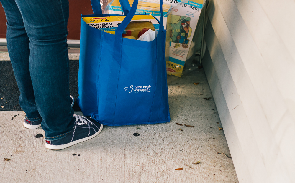 Nurse leaving bag of children's toys at door.