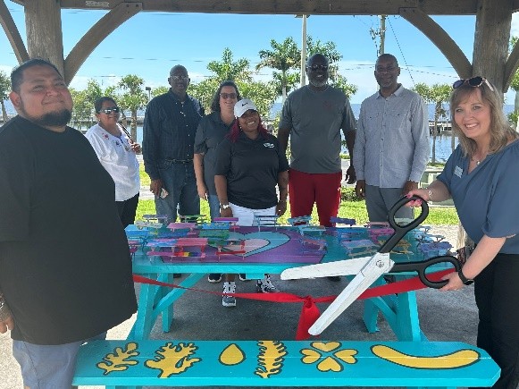 CEO cutting ribbon for Community Art Project.