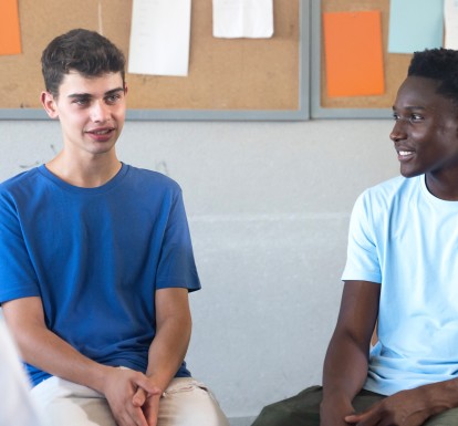 Teens sit on chairs in a circle sharing their thoughts.