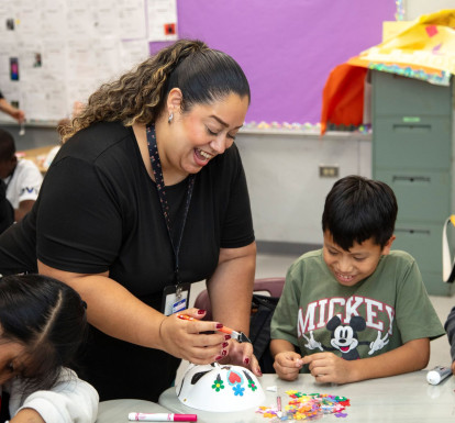 A Teen Outreach Program staffer works with students on an art project.