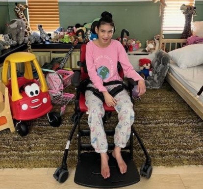 A 14-year-old girl with special needs in an adaptive chair that improves her quality of life.