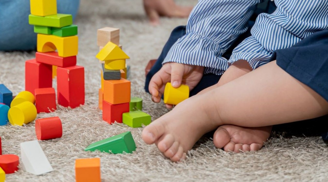 A baby playing with colorful blocks. 