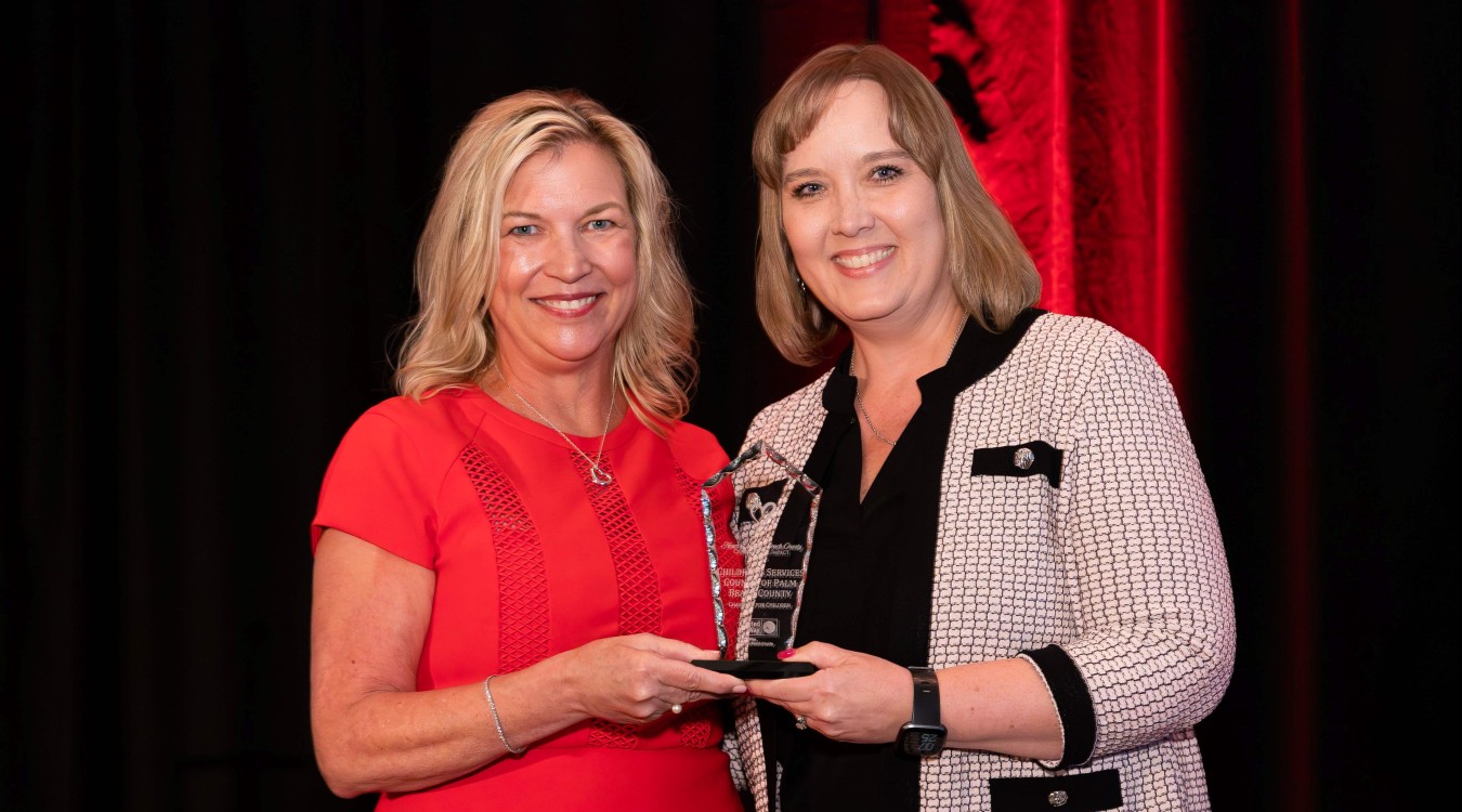 Dr. Laurie George, CEO of United Way Palm Beach County, handing the Champion for Children Award to Dr. Lisa Williams-Taylor, CEO of Children's Services Council of Palm Beach County.