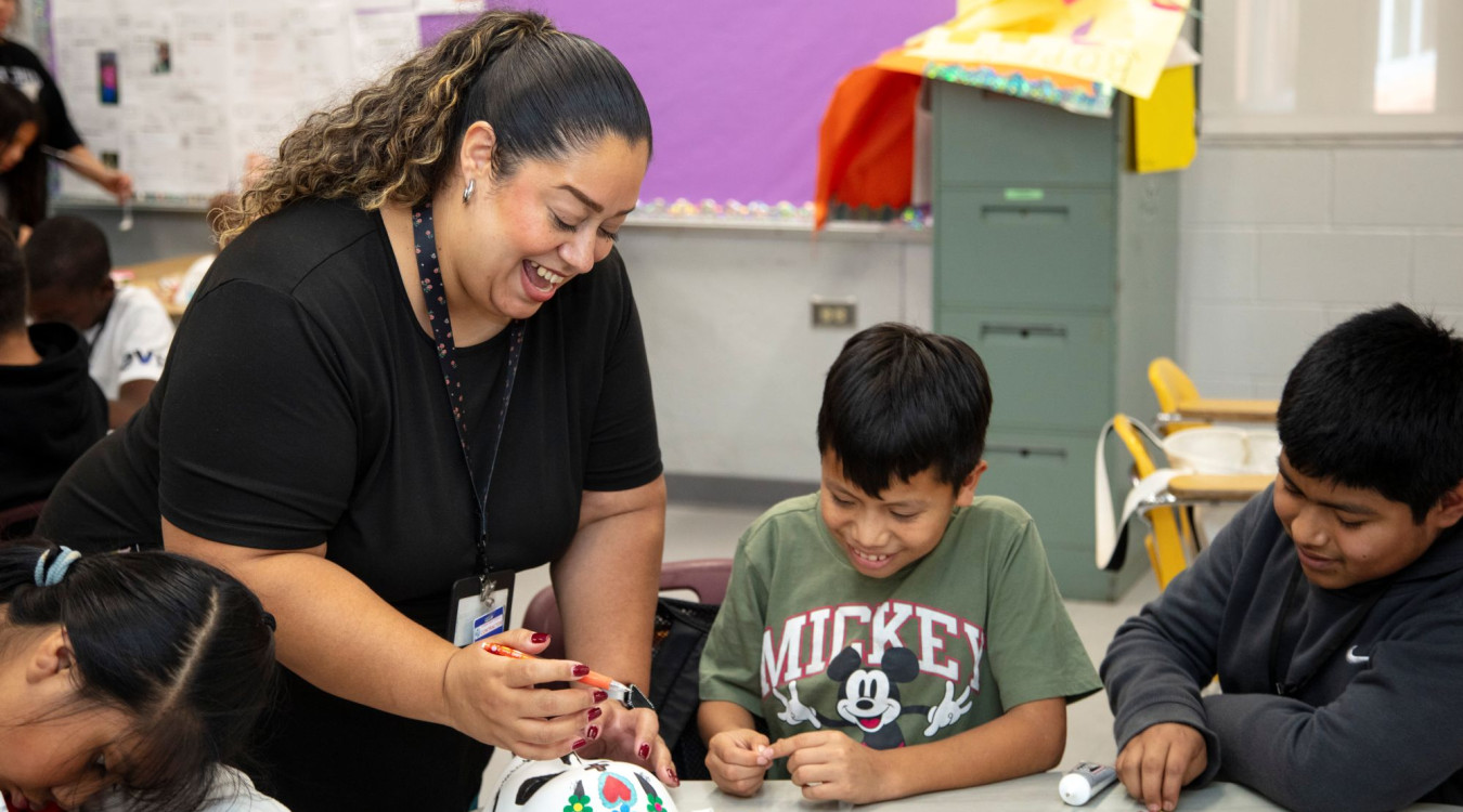 A Teen Outreach Program staffer works with students on an art project.