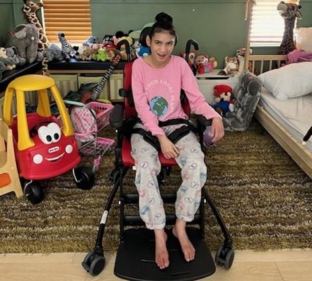 A 14-year-old girl with special needs in an adaptive chair that improves her quality of life.