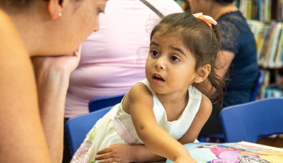 Girl reading with mother.