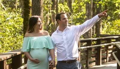 Pregnant woman with man walking in park.