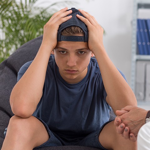 Sad teenage boy getting counseling