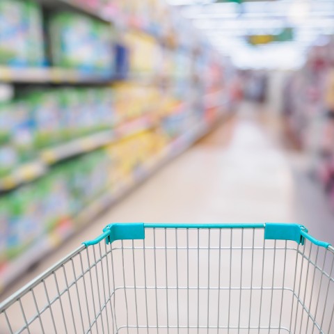 Empty grocery store cart going down aisle