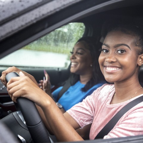 Teenage daughter driving mother in car.