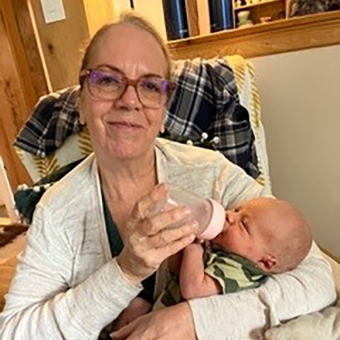 Grandmother feeding bottle to grandson.