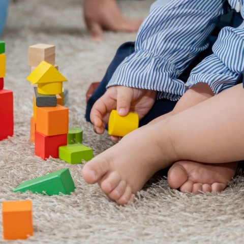 A baby playing with colorful blocks. 