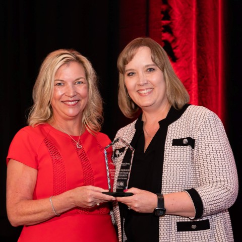 Dr. Laurie George, CEO of United Way Palm Beach County, handing the Champion for Children Award to Dr. Lisa Williams-Taylor, CEO of Children's Services Council of Palm Beach County.