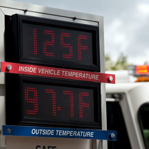 An electronic sign with two temperatures - 125F (inside vehicle temp) and 97.7F (outside temp).