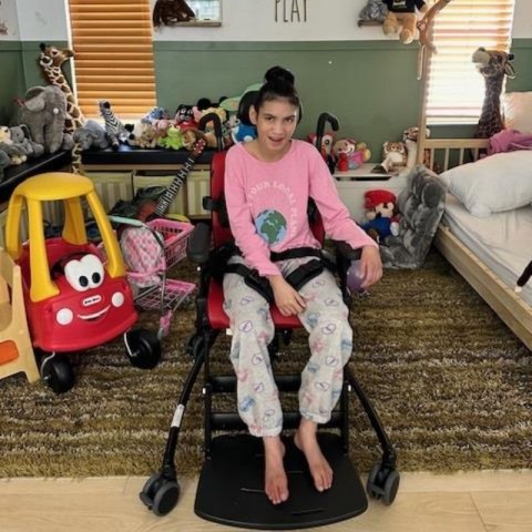 A 14-year-old girl with special needs in an adaptive chair that improves her quality of life.