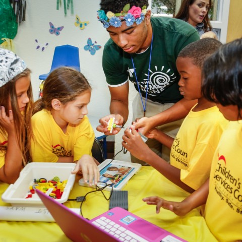 Camp counselor doing a project with school-age students